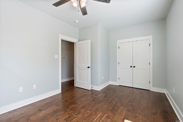 unfurnished bedroom with dark hardwood / wood-style flooring, a closet, and ceiling fan