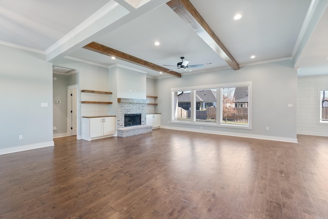 unfurnished living room featuring dark wood-type flooring, beamed ceiling, and a brick fireplace