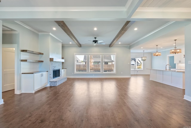 unfurnished living room featuring a fireplace, a wealth of natural light, dark hardwood / wood-style floors, and beam ceiling