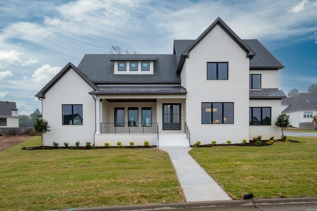 modern farmhouse featuring covered porch and a front yard