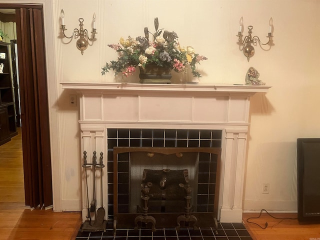 details featuring a tile fireplace and wood-type flooring