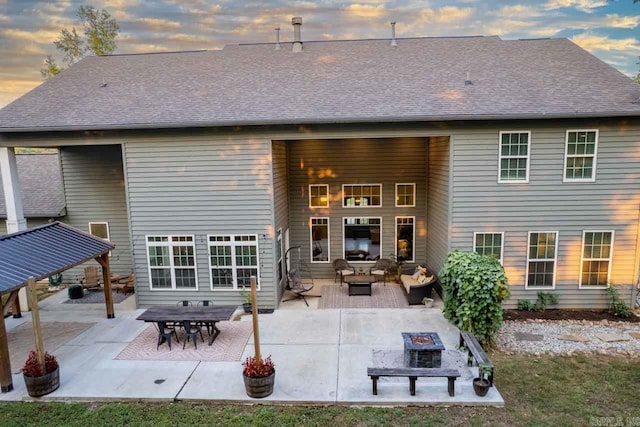 back house at dusk with an outdoor hangout area and a patio