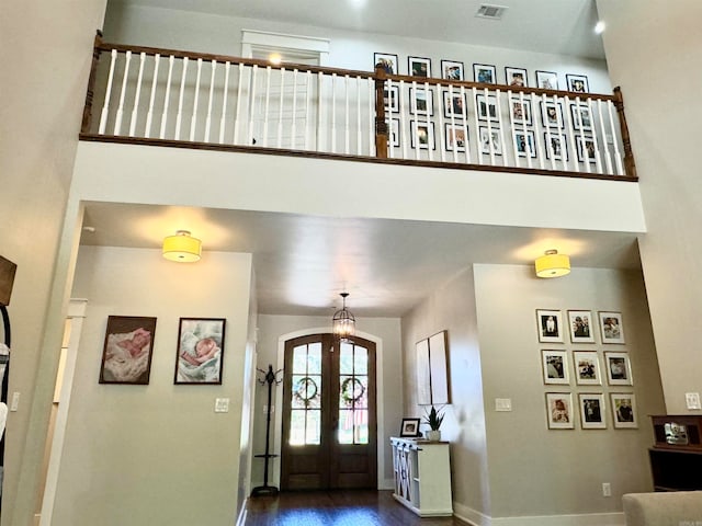 entryway with french doors, a towering ceiling, and hardwood / wood-style flooring