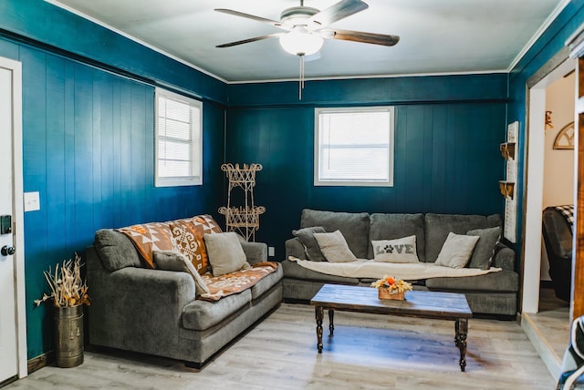 living room featuring ceiling fan, hardwood / wood-style floors, plenty of natural light, and wooden walls