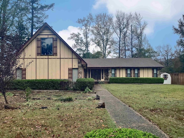 view of front of house with a front yard and a shed