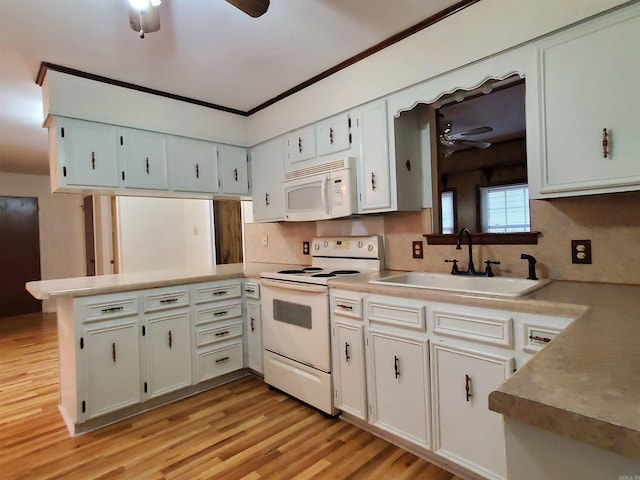 kitchen with sink, kitchen peninsula, white appliances, white cabinets, and light wood-type flooring