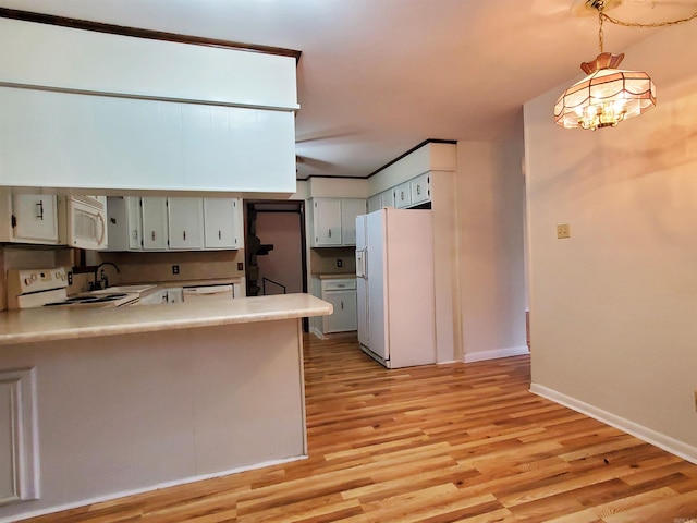 kitchen featuring kitchen peninsula, white appliances, sink, pendant lighting, and light hardwood / wood-style flooring