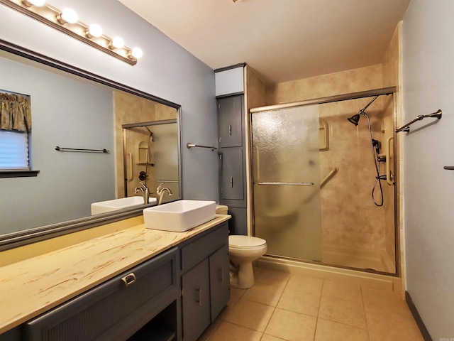 bathroom featuring toilet, a shower with door, vanity, and tile patterned flooring