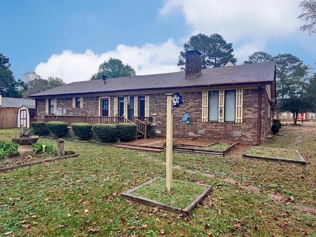 rear view of property featuring a yard and a storage shed