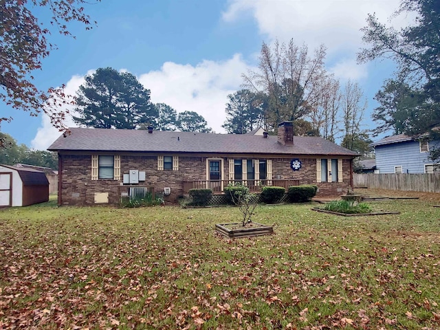 rear view of house with a yard and a shed