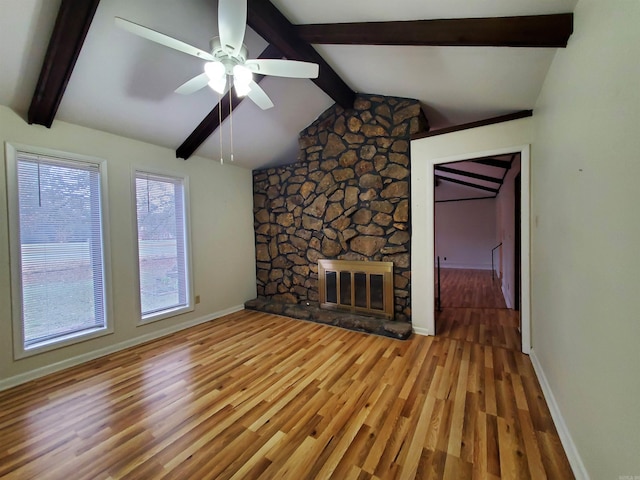 unfurnished living room with a fireplace, vaulted ceiling with beams, ceiling fan, and wood-type flooring