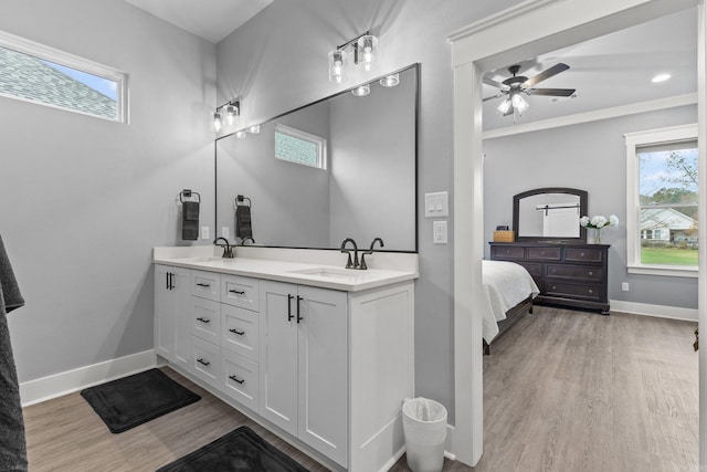 bathroom featuring a wealth of natural light, vanity, ornamental molding, and hardwood / wood-style flooring