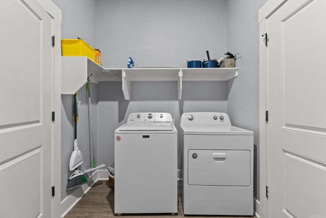 clothes washing area featuring dark hardwood / wood-style flooring and washer and dryer