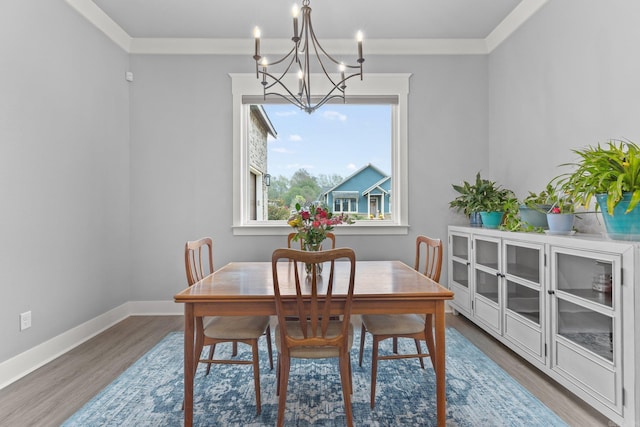 dining area featuring hardwood / wood-style flooring, an inviting chandelier, and crown molding