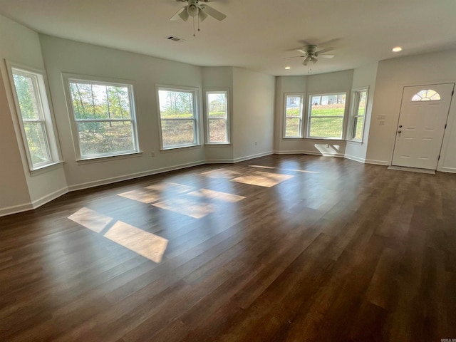 interior space featuring ceiling fan, plenty of natural light, and dark wood-type flooring