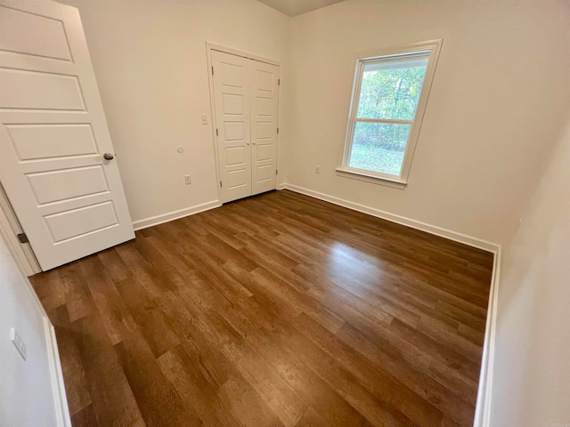 unfurnished bedroom featuring dark hardwood / wood-style flooring and a closet