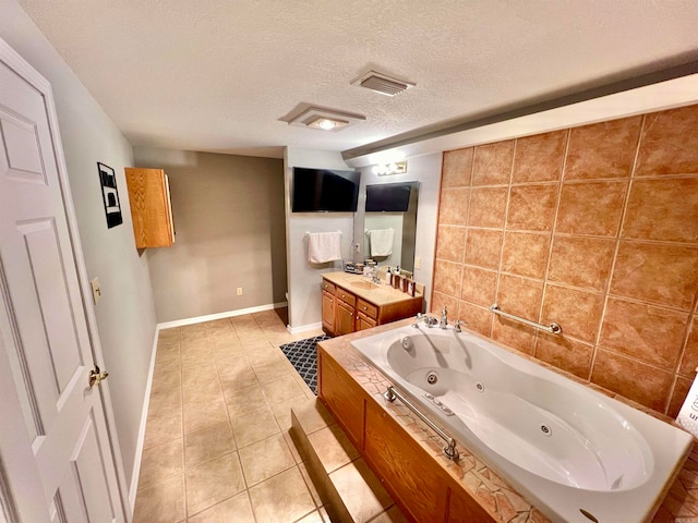 bathroom with tile patterned floors, a tub, vanity, and a textured ceiling