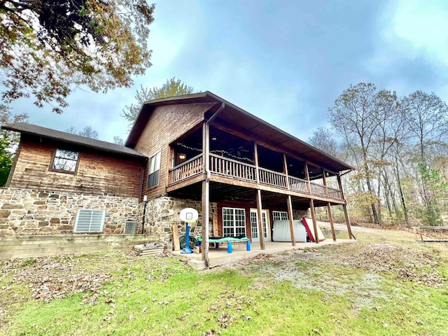 back of property featuring a yard, ceiling fan, and a patio area