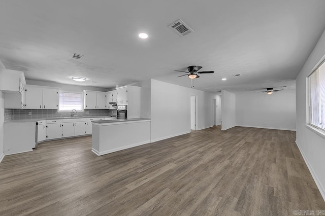 unfurnished living room with hardwood / wood-style floors, ceiling fan, and sink