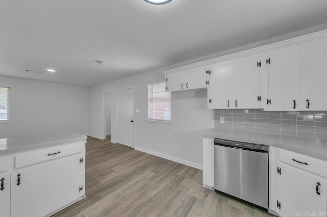 kitchen featuring decorative backsplash, white cabinetry, light hardwood / wood-style floors, and stainless steel dishwasher