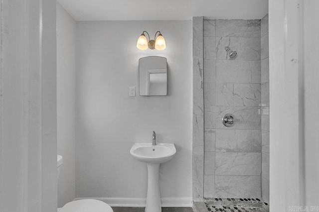 bathroom with toilet and tiled shower