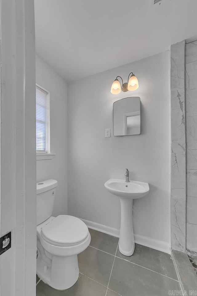 bathroom with toilet and tile patterned floors