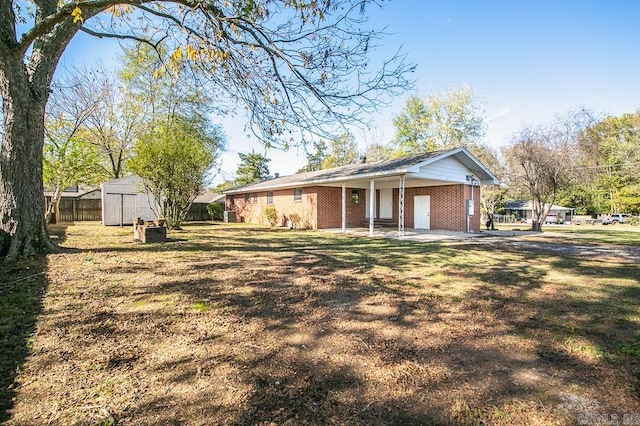 single story home with a front yard and a storage unit