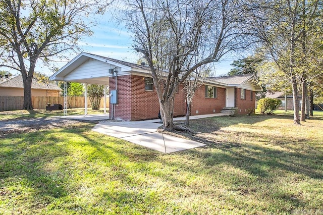 rear view of house featuring a carport and a lawn