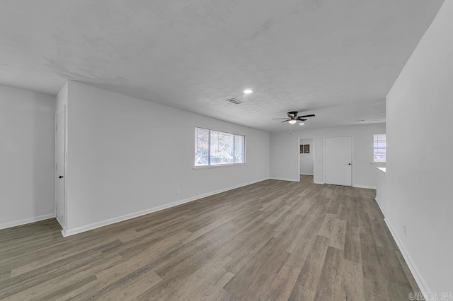 empty room with ceiling fan and light hardwood / wood-style floors