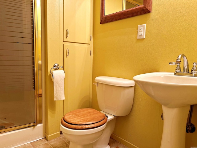 bathroom featuring tile patterned flooring, toilet, and sink