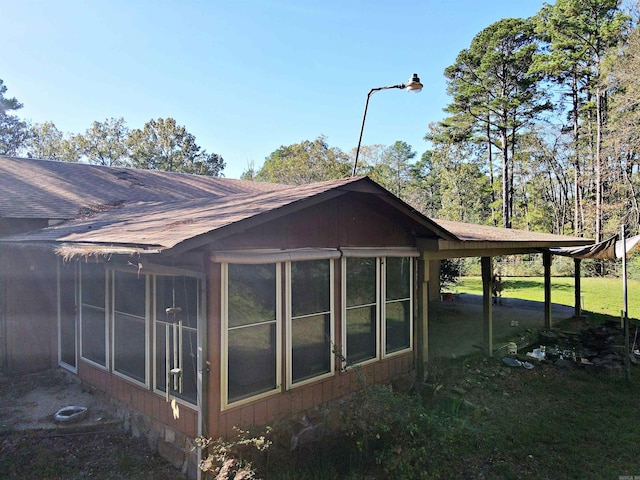 view of property exterior with a yard and a sunroom