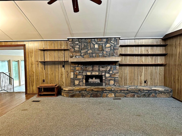 living room with wooden walls, a fireplace, ceiling fan, and wood-type flooring