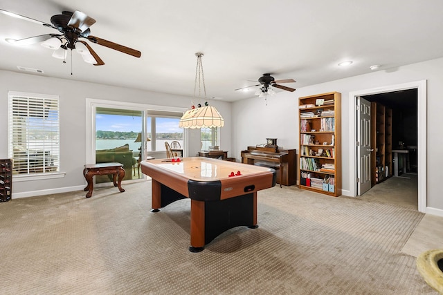 recreation room with light carpet, a water view, and ceiling fan