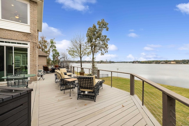 wooden deck with a water view and a lawn