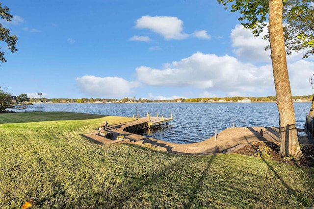 view of dock with a water view and a lawn