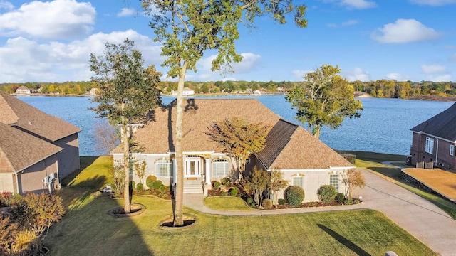 view of front of house with a front lawn and a water view