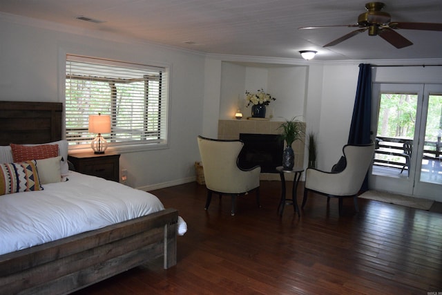 bedroom with dark wood-type flooring, access to outside, ceiling fan, ornamental molding, and a fireplace