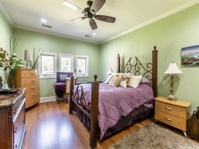 bedroom with ceiling fan, dark hardwood / wood-style floors, and crown molding