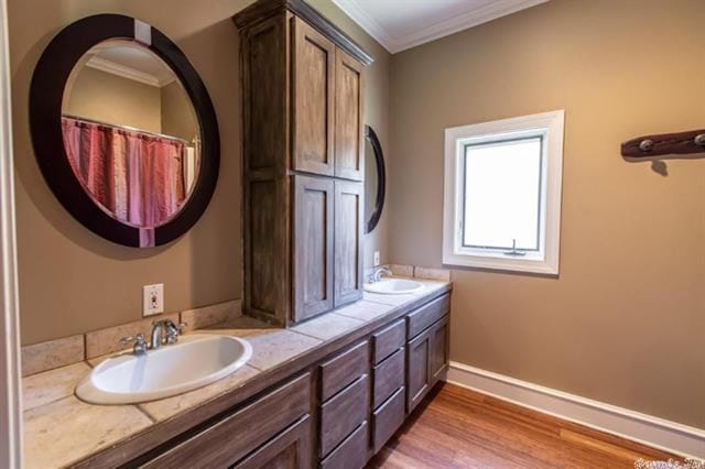 bathroom with vanity, crown molding, and hardwood / wood-style flooring