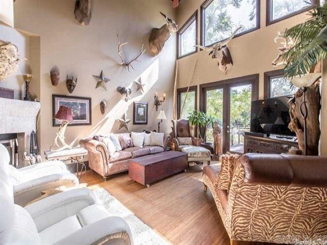 living room with french doors, wood-type flooring, a fireplace, and a high ceiling