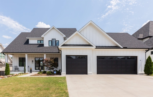 modern farmhouse style home featuring covered porch, a garage, and a front yard