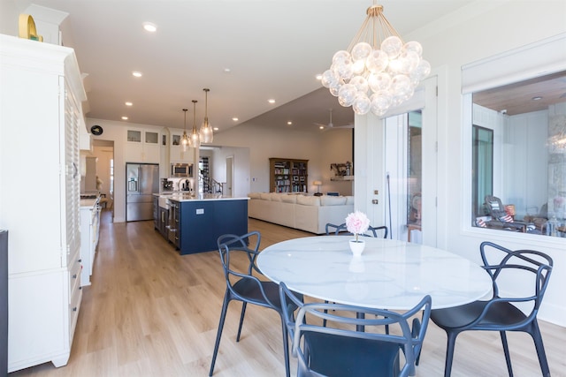 dining space featuring ornamental molding and light hardwood / wood-style flooring