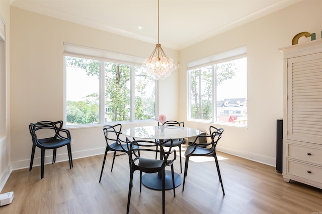 dining room with a chandelier, light hardwood / wood-style flooring, and crown molding