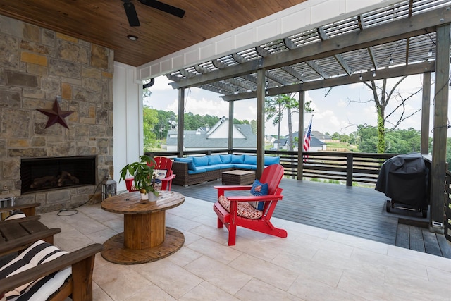 interior space with an outdoor living space with a fireplace, ceiling fan, and a grill