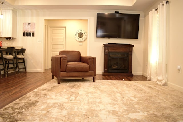 living area with dark hardwood / wood-style flooring and crown molding