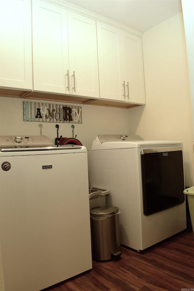 washroom with cabinets, washing machine and dryer, and dark hardwood / wood-style floors