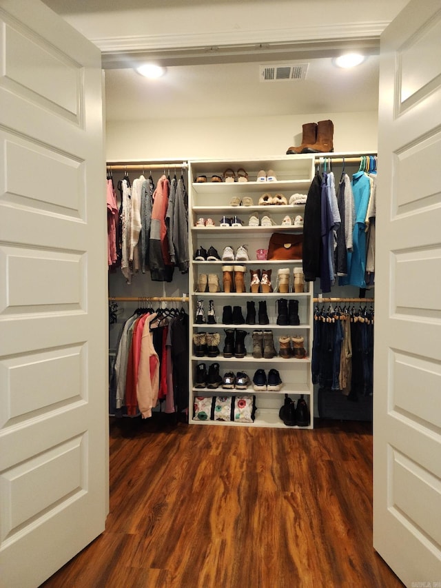 walk in closet with dark wood-type flooring