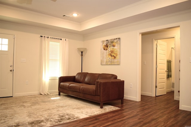 living room featuring dark wood-type flooring, a wealth of natural light, and ornamental molding