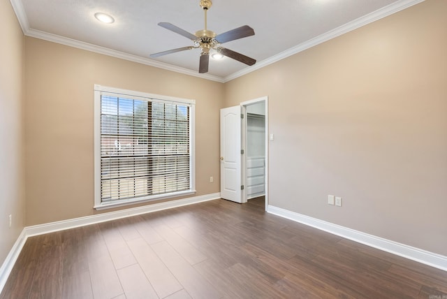 empty room with ceiling fan, dark hardwood / wood-style floors, and ornamental molding