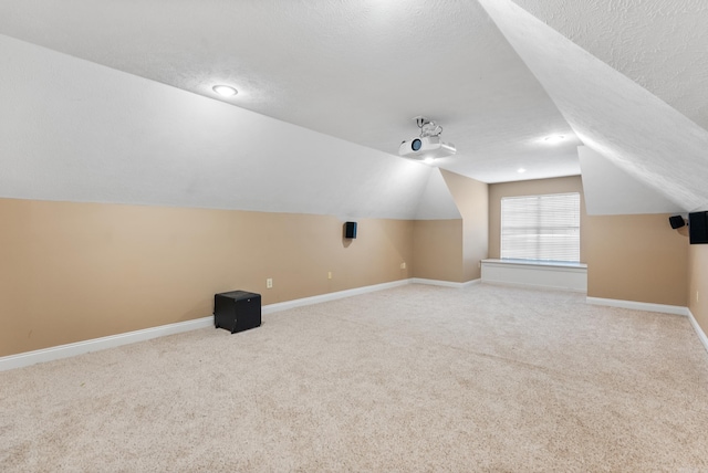 bonus room with a textured ceiling, carpet, and vaulted ceiling